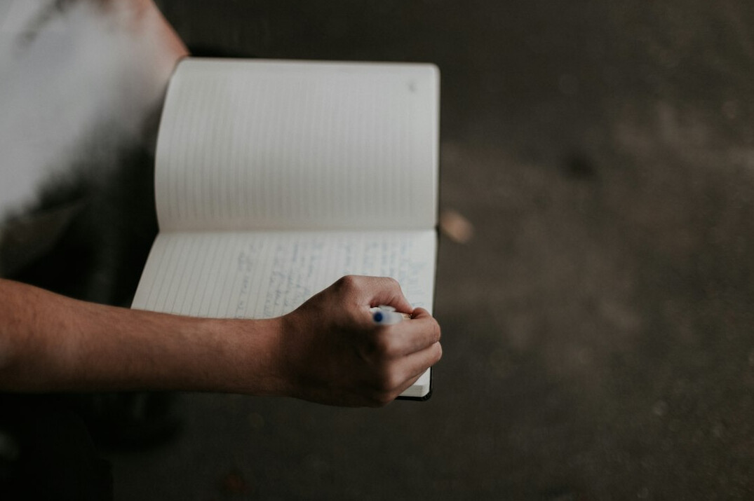 person writing in notebook