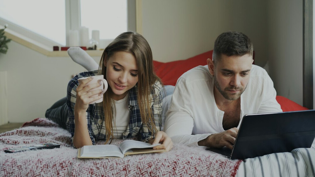 couple calculating expenses on laptop